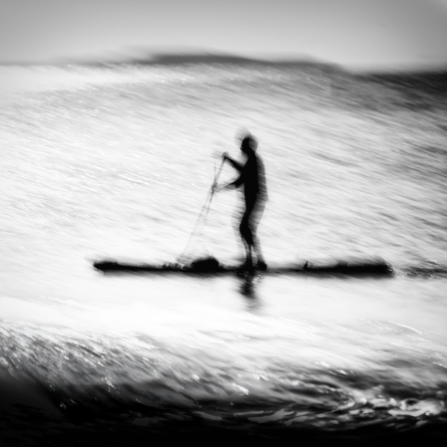 Hikari no Umi — lone paddleboarder silhouette on a glittering silver sea, black and white fine art photography