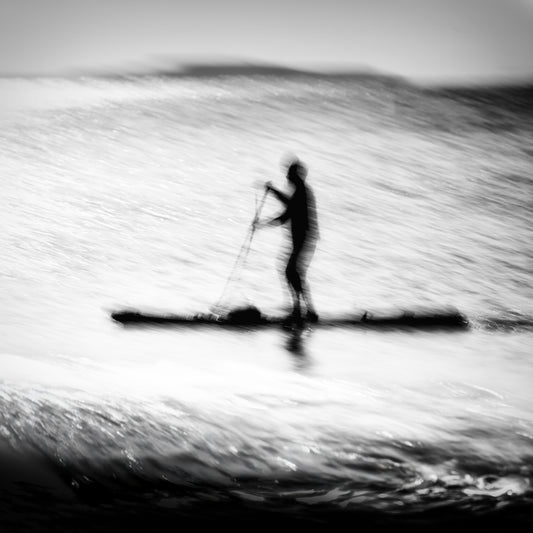 Hikari no Umi — lone paddleboarder silhouette on a glittering silver sea, black and white fine art photography