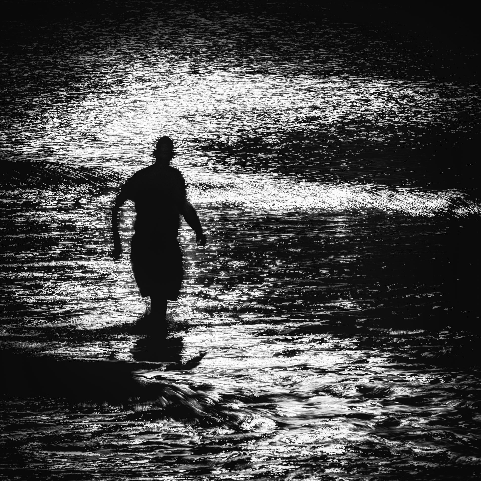 Mizu no Tobira — lone figure wading through breaking waves backlit on the Dorset coast, black and white fine art photography