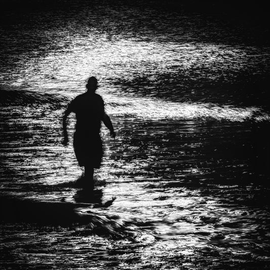 Mizu no Tobira — lone figure wading through breaking waves backlit on the Dorset coast, black and white fine art photography