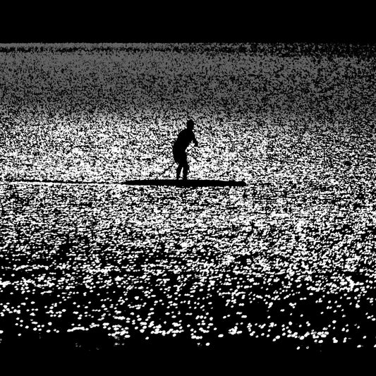 Nami no Tabibito — paddleboarder silhouette on a vast glittering silver sea, black and white fine art photography