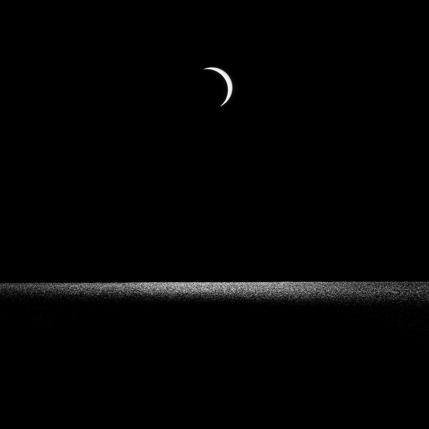 Partial Eclipse — crescent moon over a still Dorset horizon, black and white fine art photography